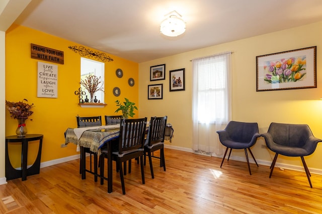 dining room featuring baseboards and light wood-type flooring