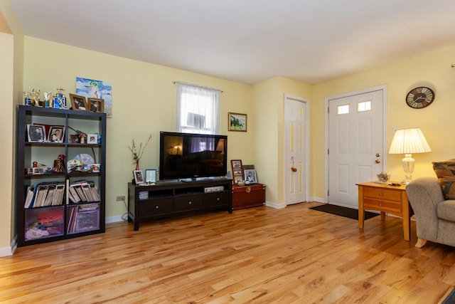 living room with baseboards and light wood-type flooring
