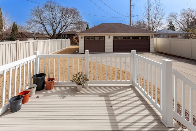 wooden deck featuring a fenced backyard, an outbuilding, and a detached garage