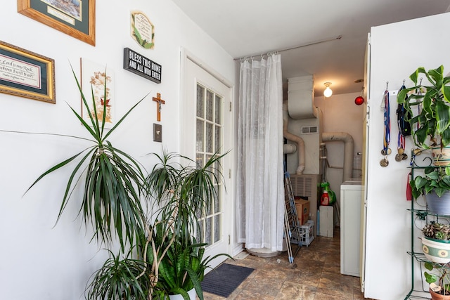 interior space featuring stone finish floor, visible vents, and washer / clothes dryer