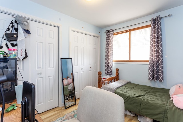 bedroom featuring two closets and light wood-style floors