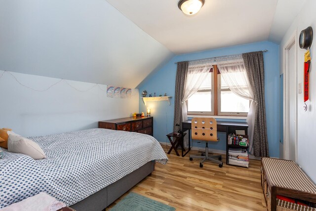bedroom featuring lofted ceiling and wood finished floors
