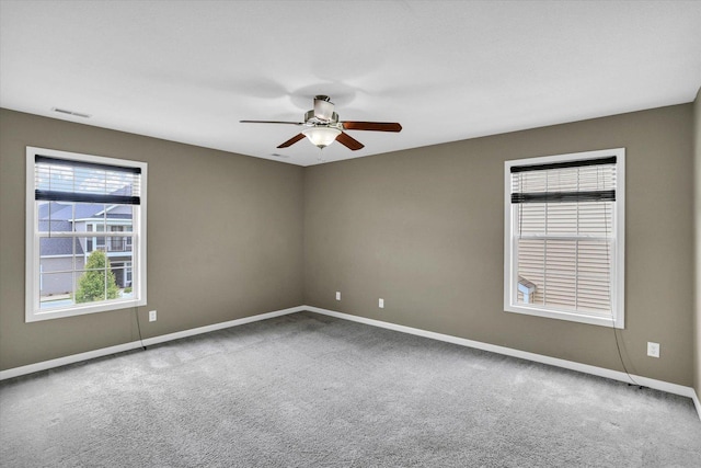 spare room with a ceiling fan, baseboards, and carpet flooring