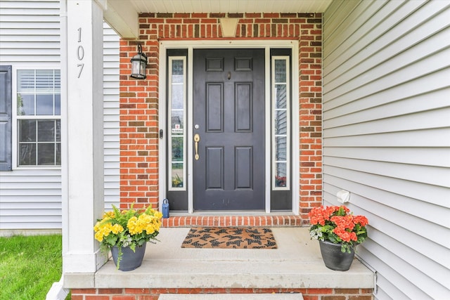 view of exterior entry with brick siding