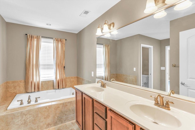 bathroom with a garden tub, double vanity, and toilet