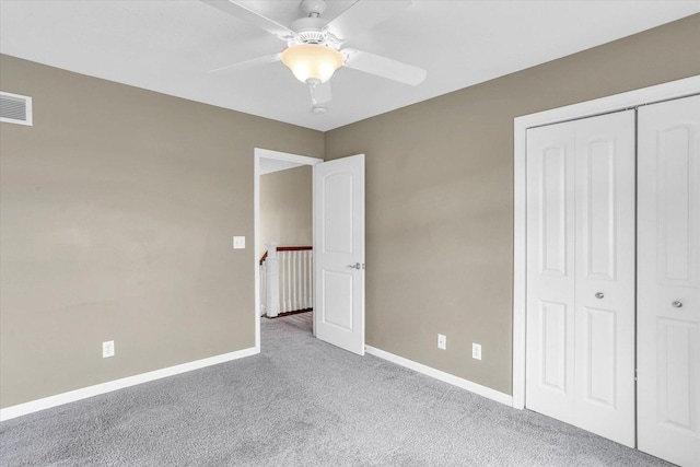 unfurnished bedroom featuring carpet, a closet, baseboards, and a ceiling fan