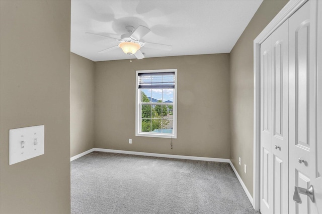 unfurnished bedroom with baseboards, carpet flooring, a closet, and ceiling fan