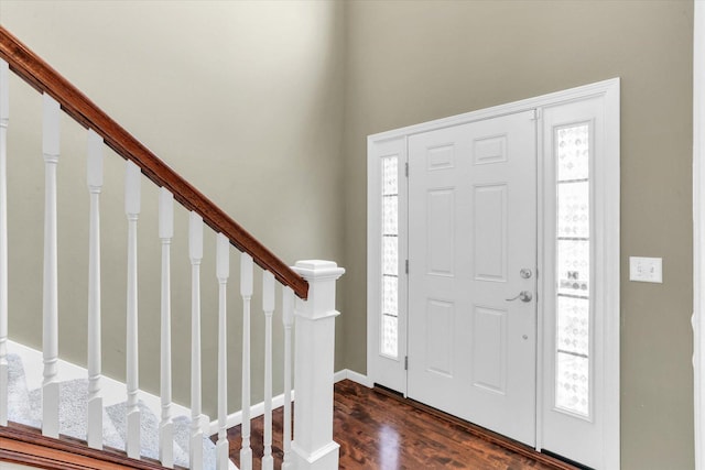 foyer entrance with stairway, dark wood-type flooring, and plenty of natural light
