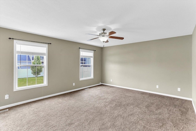 spare room featuring a ceiling fan, carpet flooring, and baseboards