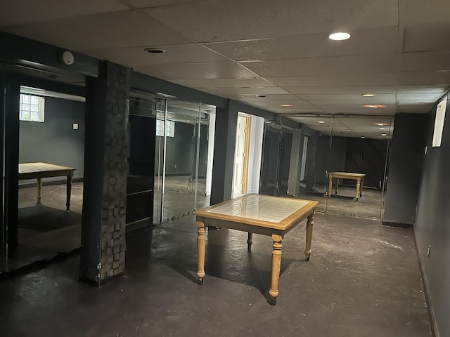 basement featuring baseboards and a paneled ceiling