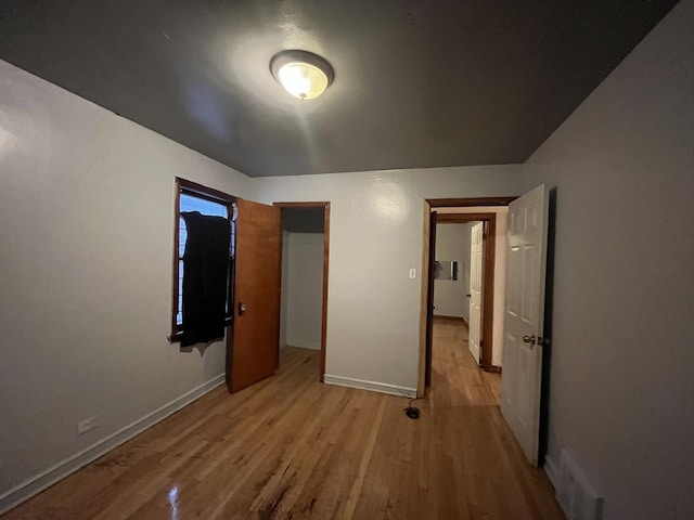 unfurnished bedroom featuring baseboards and light wood-style floors