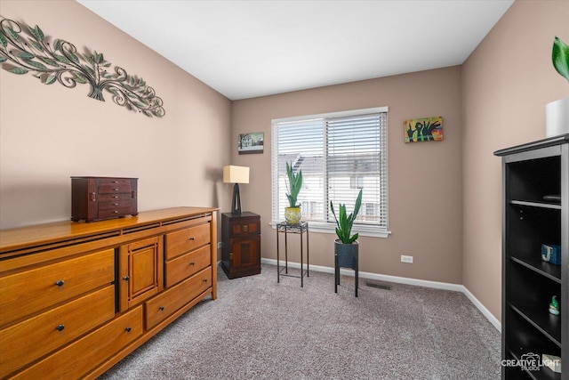 office with baseboards, visible vents, and light carpet