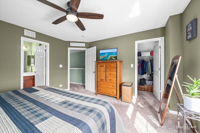 bedroom featuring visible vents, a closet, light carpet, a spacious closet, and a ceiling fan
