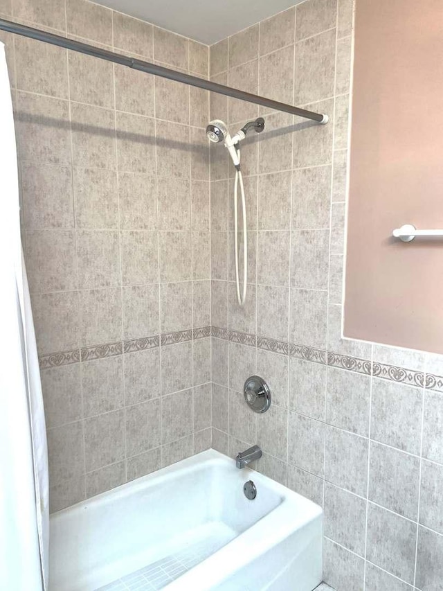 full bathroom with tile walls and shower / bathtub combination with curtain