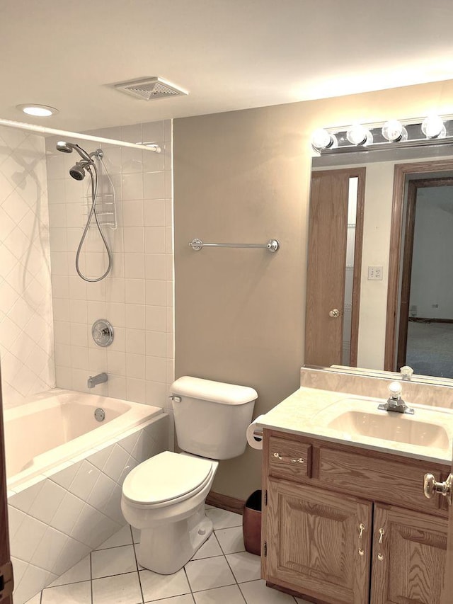bathroom with vanity, toilet, tile patterned floors, visible vents, and tiled shower / bath