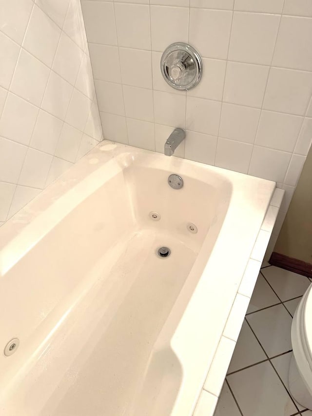 bathroom with tile patterned floors, toilet, and a bath