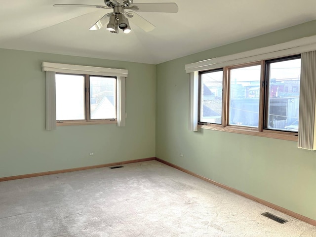 unfurnished room with carpet floors, baseboards, ceiling fan, and visible vents