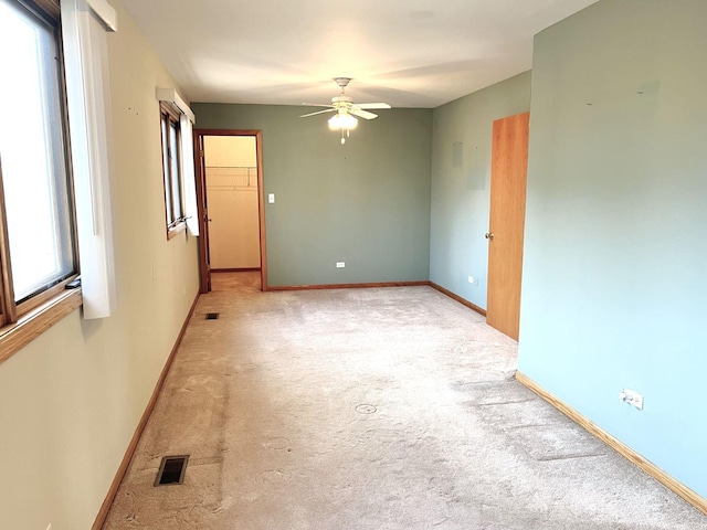 unfurnished room with carpet, baseboards, ceiling fan, and visible vents