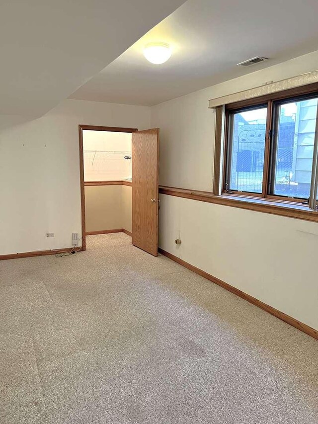 interior space with baseboards, visible vents, and light colored carpet