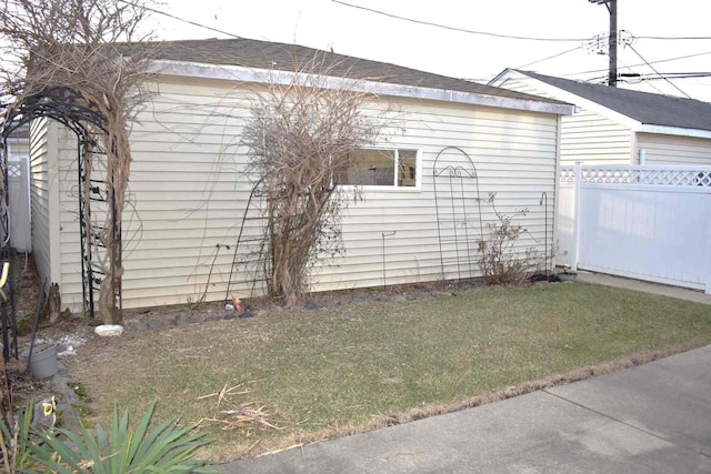 view of home's exterior with fence and a lawn