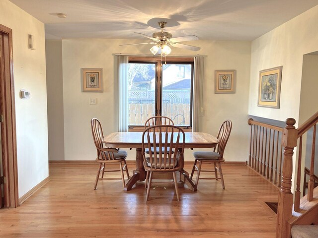 dining space with a ceiling fan, light wood-style flooring, and baseboards