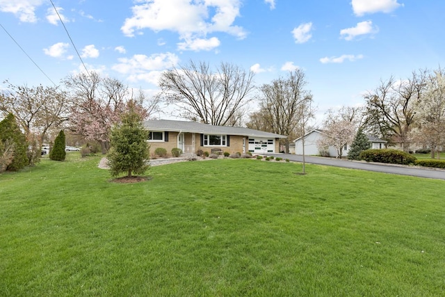 single story home with driveway, a front yard, and a garage