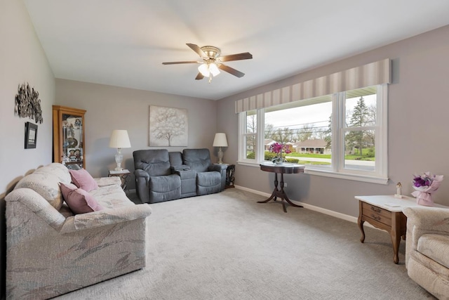 carpeted living room featuring ceiling fan and baseboards