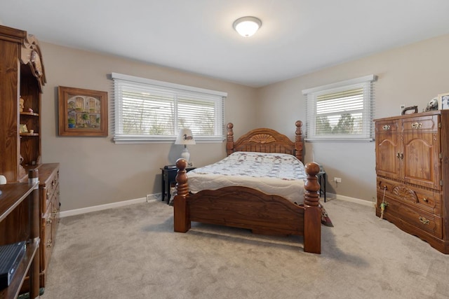 bedroom featuring multiple windows, light carpet, and baseboards