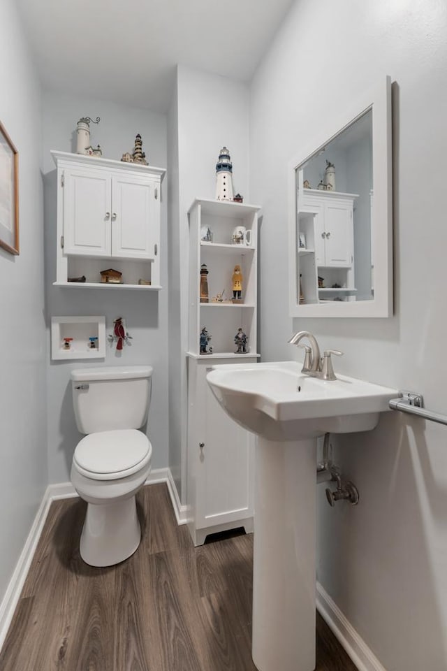 bathroom with toilet and wood finished floors
