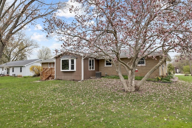 exterior space with cooling unit and a yard