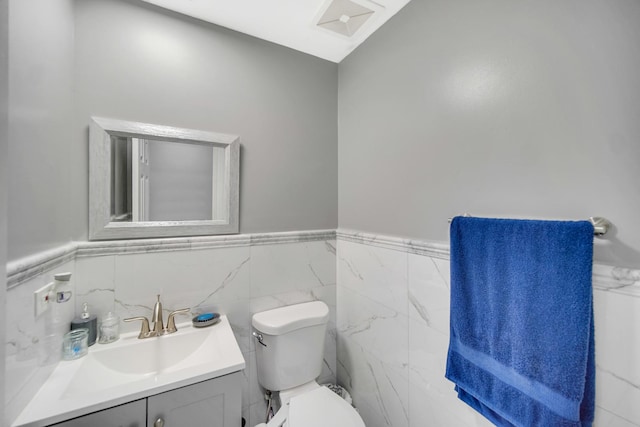 127 Tottenham Ln, Elk Grove Village, IL 60007 - half bathroom featuring toilet, a wainscoted wall, tile walls, and vanity