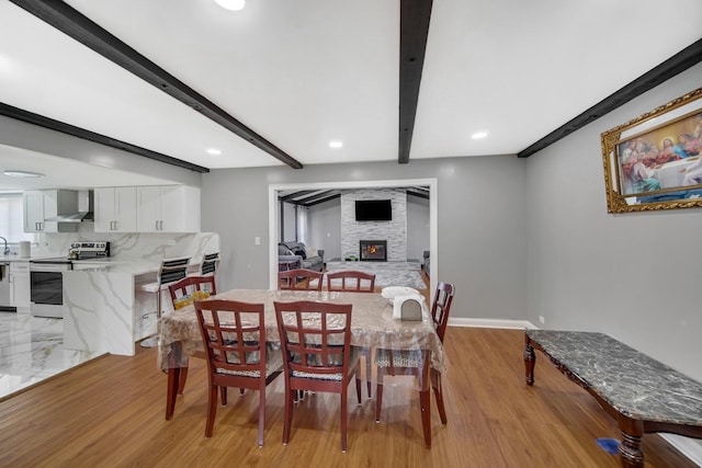 127 Tottenham Ln, Elk Grove Village, IL 60007 - dining area with light wood-style flooring, recessed lighting, a stone fireplace, and beam ceiling