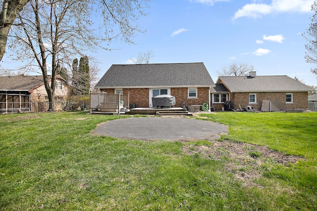 493 W Chebanse Ave, Chebanse, IL 60922 - back of house with a patio area, a lawn, a deck, fence, and brick siding