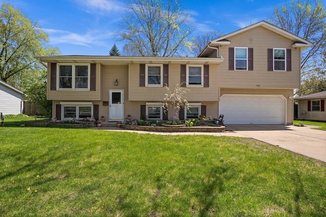 raised ranch with a garage, concrete driveway, and a front lawn