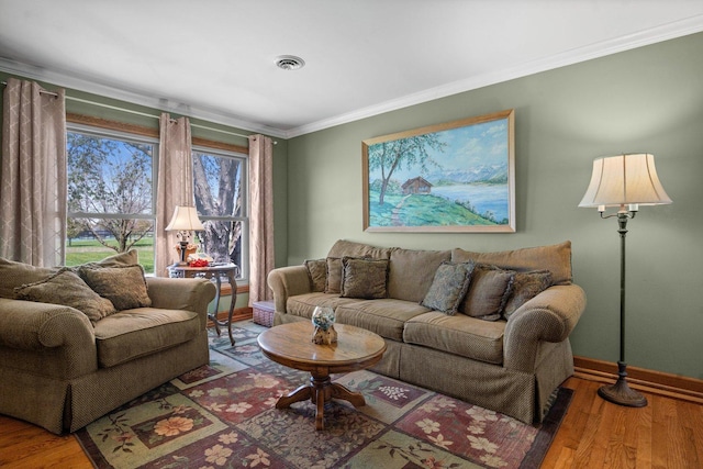 living room with crown molding, baseboards, visible vents, and wood finished floors