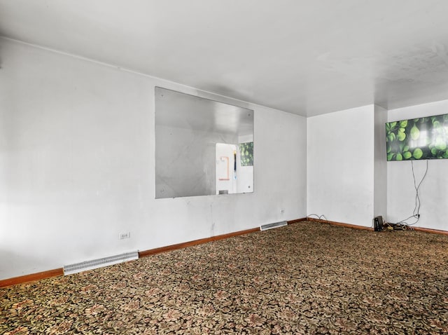 empty room with baseboards, carpet floors, and visible vents