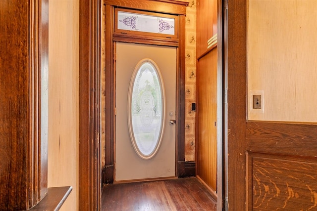 doorway to outside featuring baseboards and wood finished floors