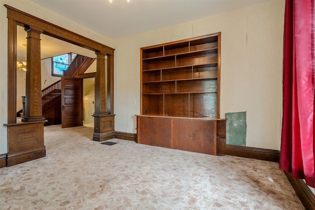 interior space with baseboards, carpet flooring, and ornate columns