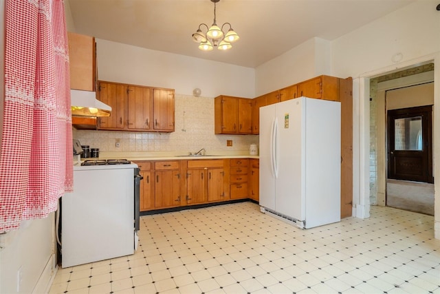 kitchen featuring white appliances, under cabinet range hood, a sink, and light floors