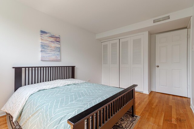 bedroom featuring visible vents, a closet, and light wood-style floors