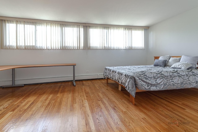 bedroom featuring a baseboard radiator and wood finished floors
