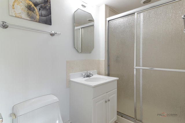 bathroom with a stall shower, toilet, and vanity