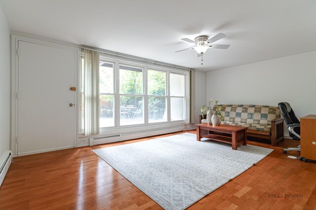 living area featuring a ceiling fan, wood finished floors, and baseboard heating