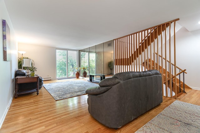 living area with stairway, expansive windows, baseboards, light wood finished floors, and visible vents