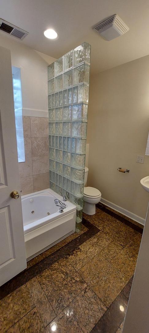 full bath with baseboards, granite finish floor, visible vents, and toilet