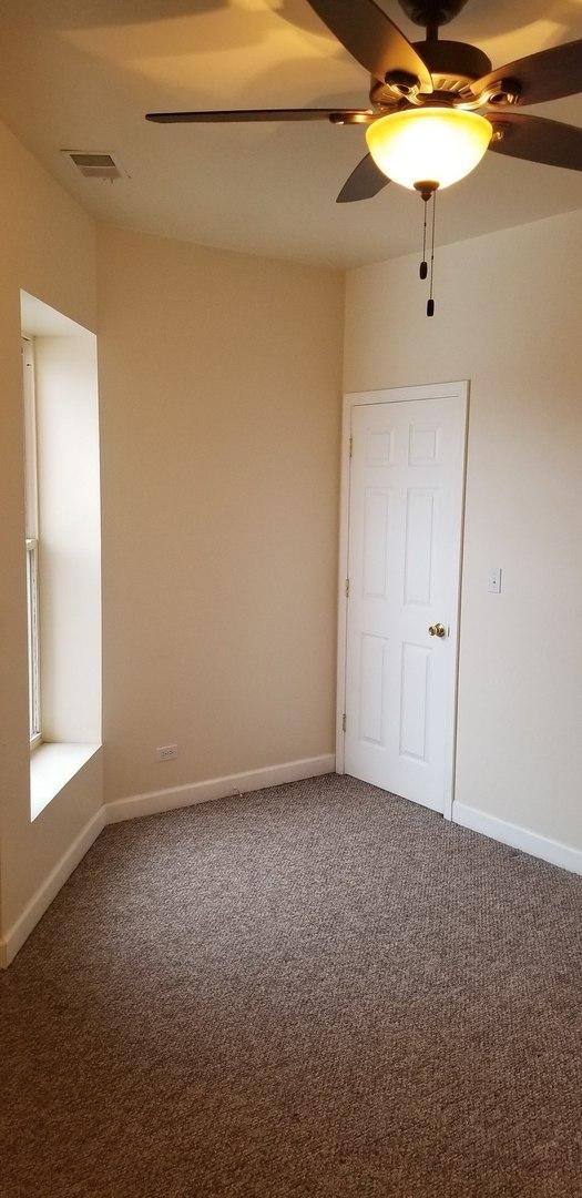 carpeted spare room with baseboards, visible vents, and a ceiling fan