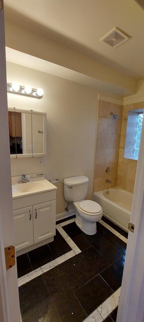 bathroom with visible vents,  shower combination, toilet, and vanity