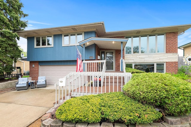 split foyer home with brick siding, driveway, and a garage