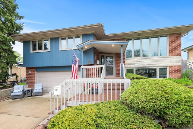 view of front of house featuring an attached garage, driveway, and brick siding