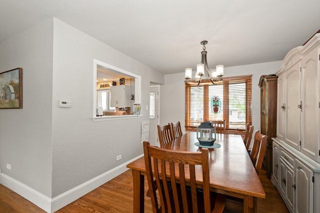 dining area with baseboards, an inviting chandelier, and a healthy amount of sunlight